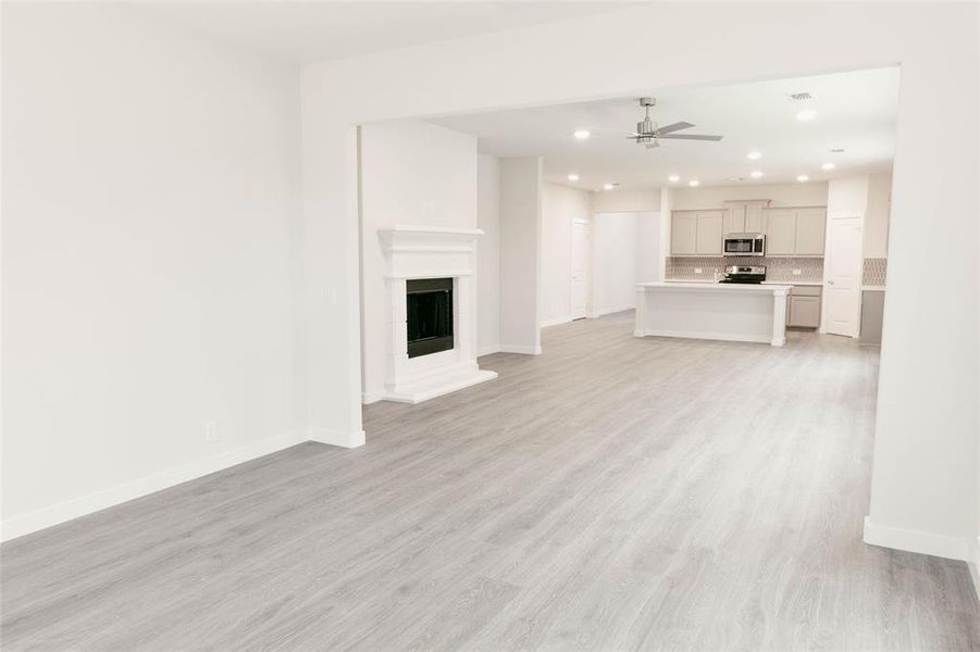 Unfurnished living room featuring light hardwood / wood-style flooring and ceiling fan