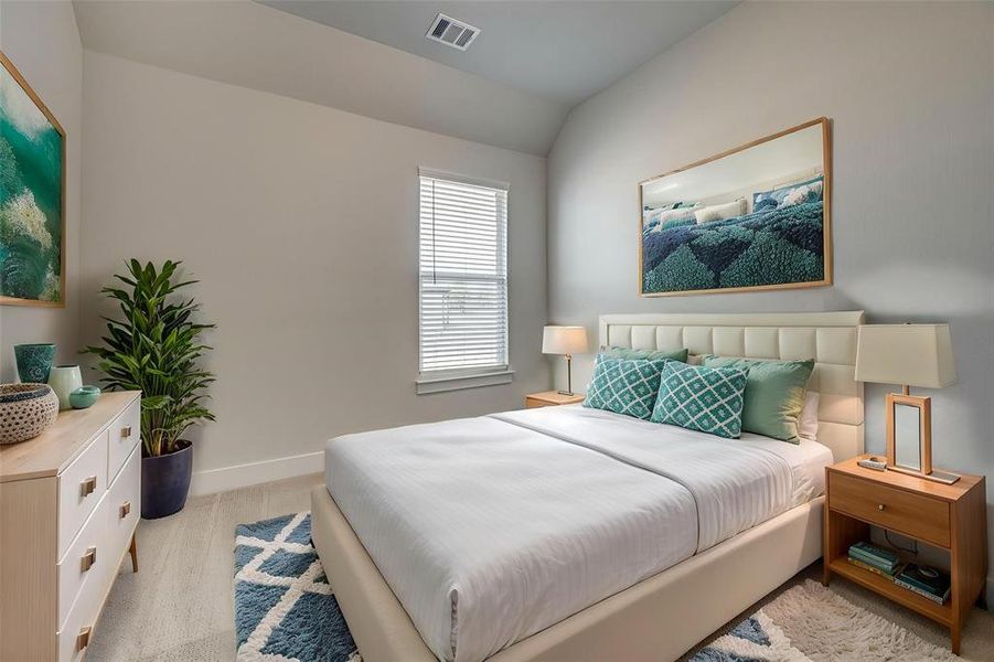 Bedroom featuring light colored carpet, baseboards, vaulted ceiling, and visible vents