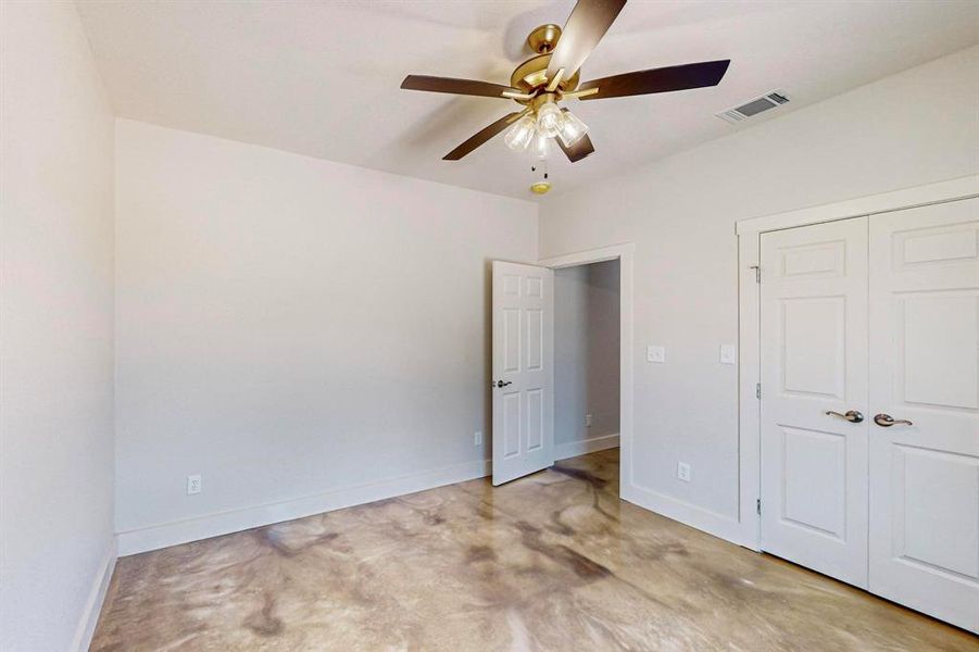 Unfurnished bedroom featuring ceiling fan and a closet