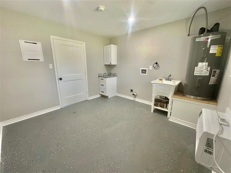 Downstairs Laundry room with hookup for a washing machine, water heater, hookup for an electric dryer, and cabinet space Downstairs Laundry room with hookup for a washing machine, water heater, hookup for an electric dryer, and cabinet space