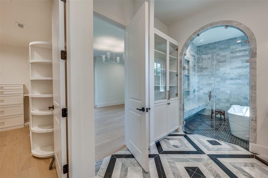 Primary bathroom with a freestanding bath, a shower stall, and wood finished floors
