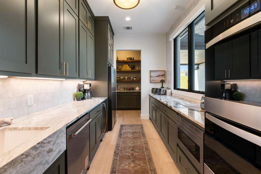 Kitchen featuring backsplash, stainless steel appliances, light stone counters, open shelves, and recessed lighting Kitchen featuring backsplash, stainless steel appliances, light stone counters, open shelves, and recessed lighting