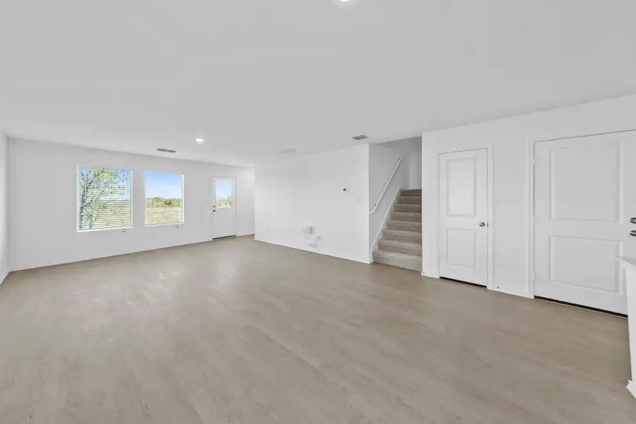 Unfurnished living room with stairway, light wood-type flooring, and recessed lighting