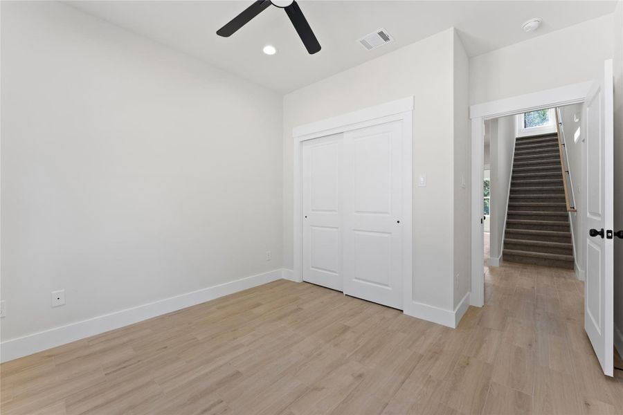 Secondary Bedroom #1 looking back towards the door.Both downstairs bedrooms feature large windows overlooking the quiet backyard and natural greenspace beyond. The are situated on opposite sides of the home with a large secondary bathroom in a hallway between them.