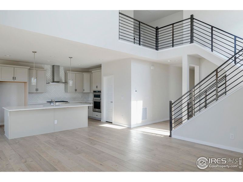 The open concept living area has open sight lines and the stunning staircase is the centerpiece of the home