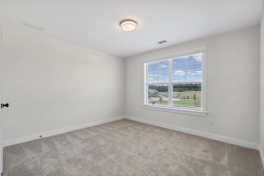 Room featuring a double window with white blinds, neutral carpeting, and white walls Room featuring a double window with white blinds, neutral carpeting, and white walls