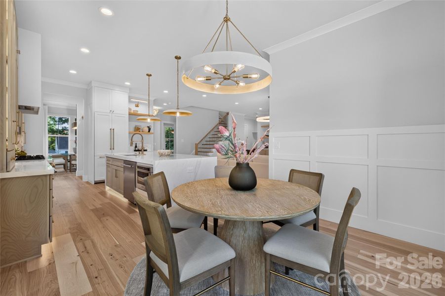 Breakfast area with wainscoting, crown molding, bespoken lighting
