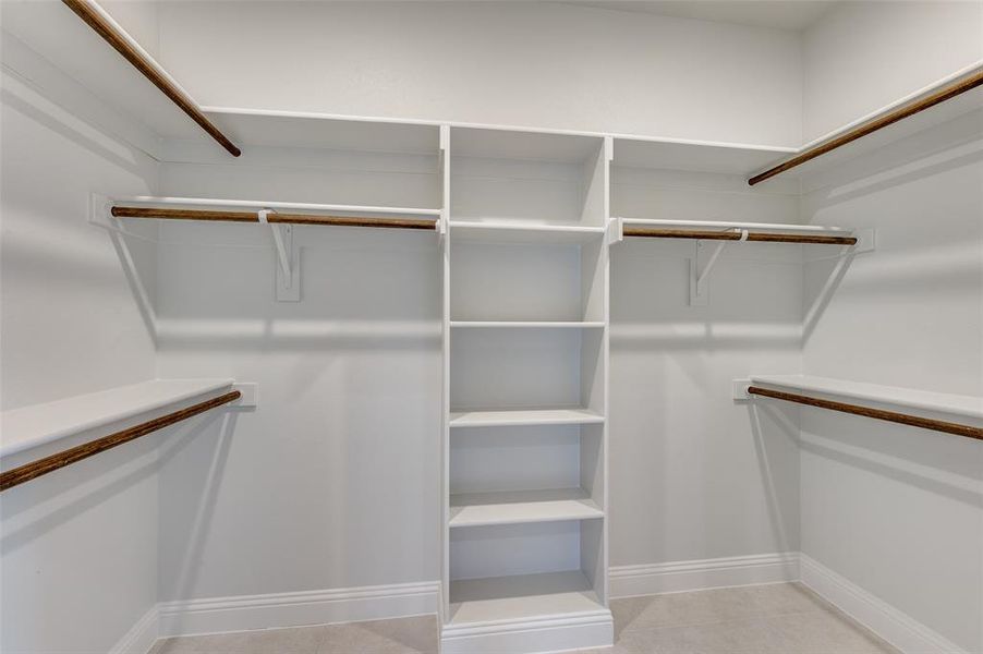 Walk in closet with light tile patterned flooring