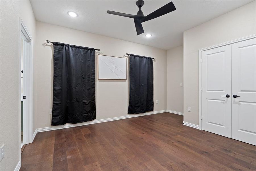 Unfurnished bedroom with dark wood-style flooring, a ceiling fan, recessed lighting, and a closet Unfurnished bedroom with dark wood-style flooring, a ceiling fan, recessed lighting, and a closet