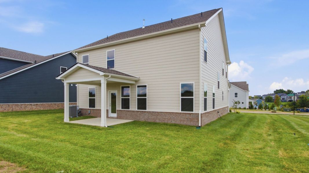 Rear exterior of home with sodded backyard