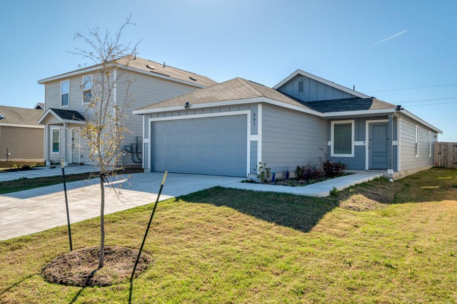 This property features light gray siding, a dark gray roof, and an attached garage with a gray door