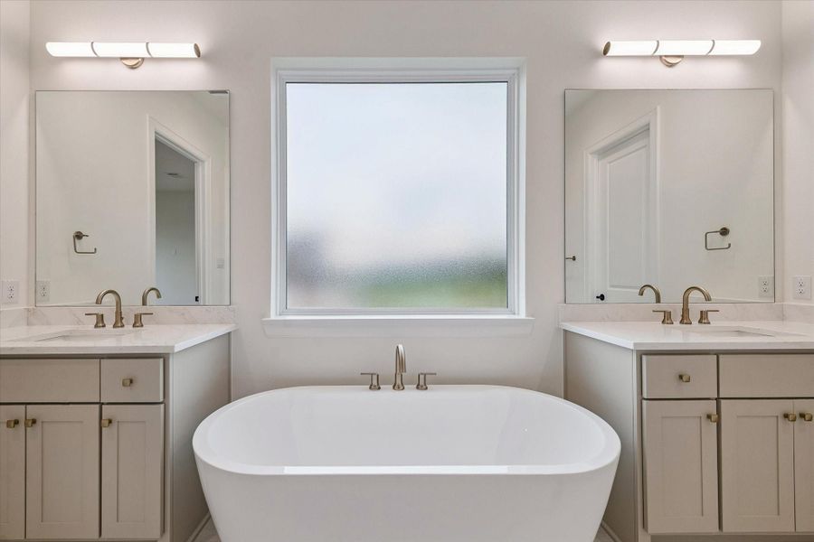 The vanities are separated by a soaking tub.