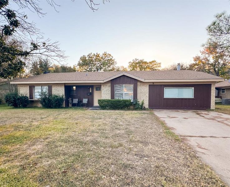 Ranch-style house featuring a front lawn, brick siding, and concrete driveway