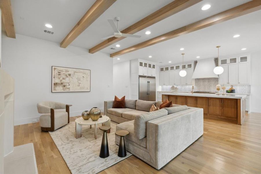 Living room with light wood-type flooring, beamed ceiling, and ceiling fan