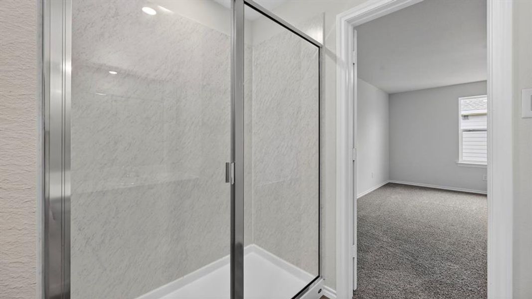 Shower enclosure with clear glass door, chrome frame, and light-toned shower surround
