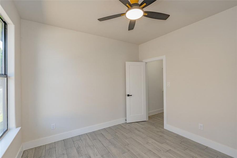 Unfurnished room featuring ceiling fan and light wood-type flooring