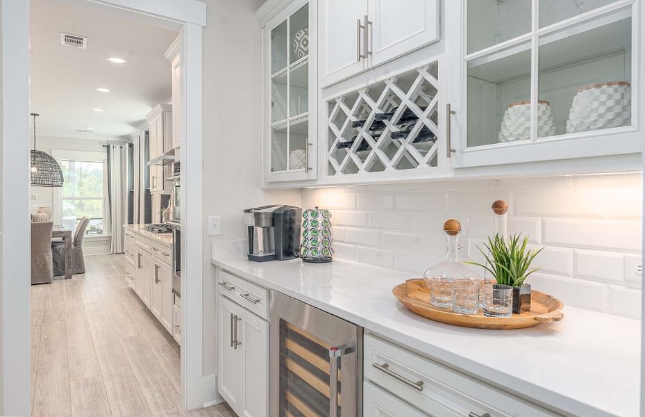 Optional Beverage Center with white cabinets, tile backsplash, wine refrigerator and wine storage areas