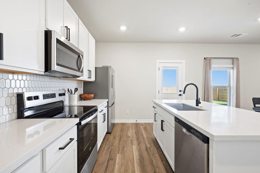 Gleaming stone countertops and a spacious central island define this modern culinary space. Gleaming stone countertops and a spacious central island define this modern culinary space.