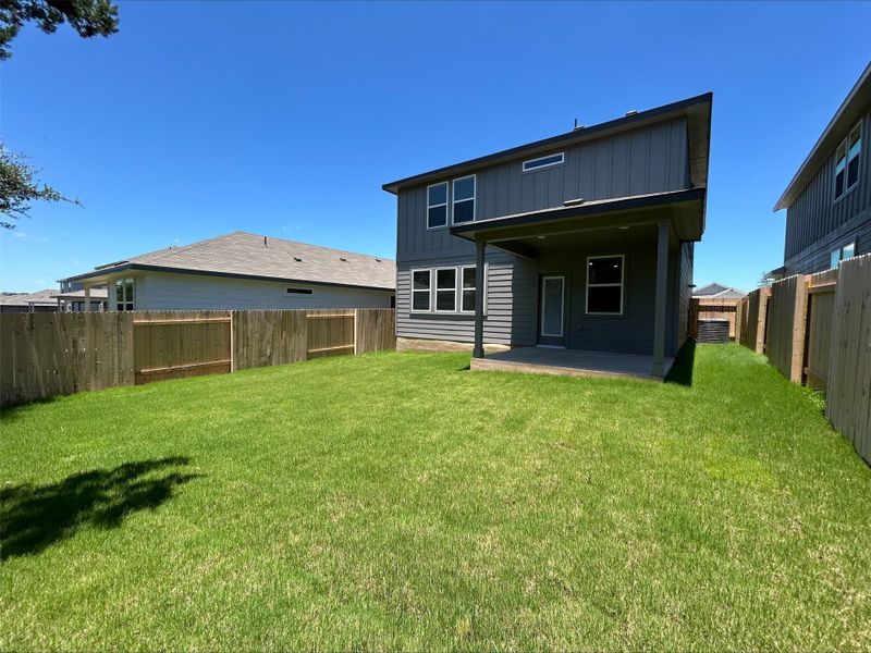 Rear view of house with a patio, a fenced backyard, and board and batten siding