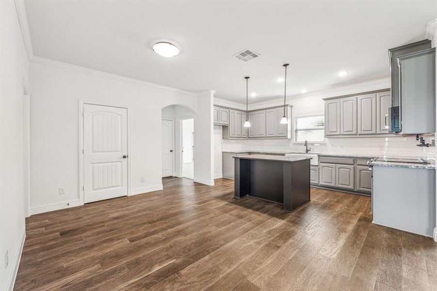 Kitchen featuring a center island, dark wood-type flooring, and gray cabinetry