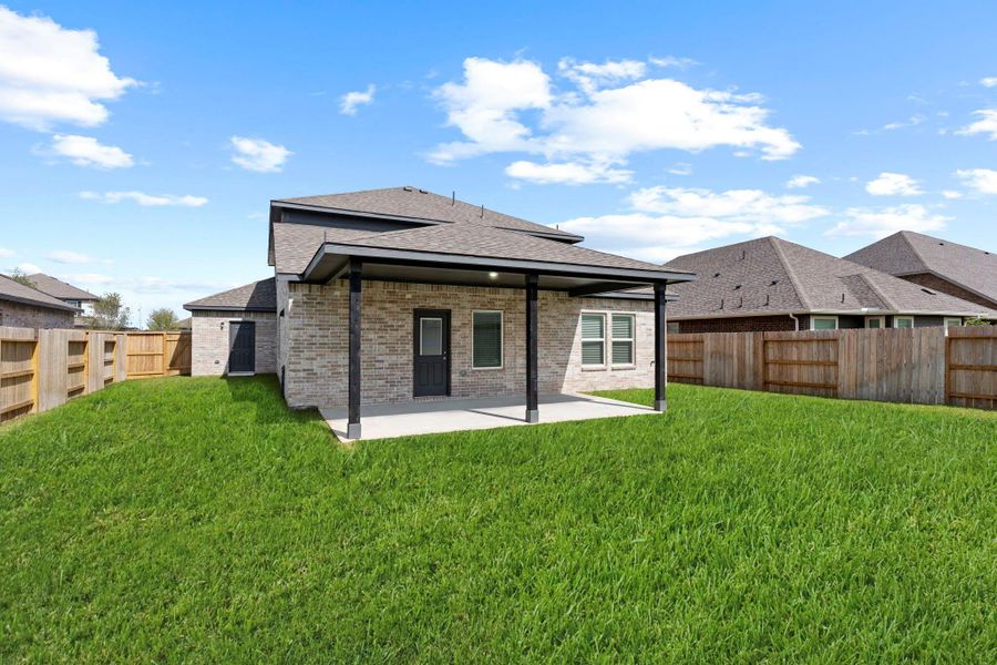 Beautiful rear elevation featuring full brick construction and generous windows that fill the interior with natural light. The large fenced yard ensures privacy while offering an ideal setting for play or pets. Beautiful rear elevation featuring full brick construction and generous windows that fill the interior with natural light. The large fenced yard ensures privacy while offering an ideal setting for play or pets.