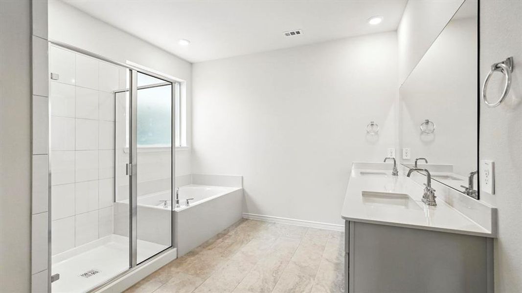 Bathroom featuring a bath, double vanity, and a shower stall