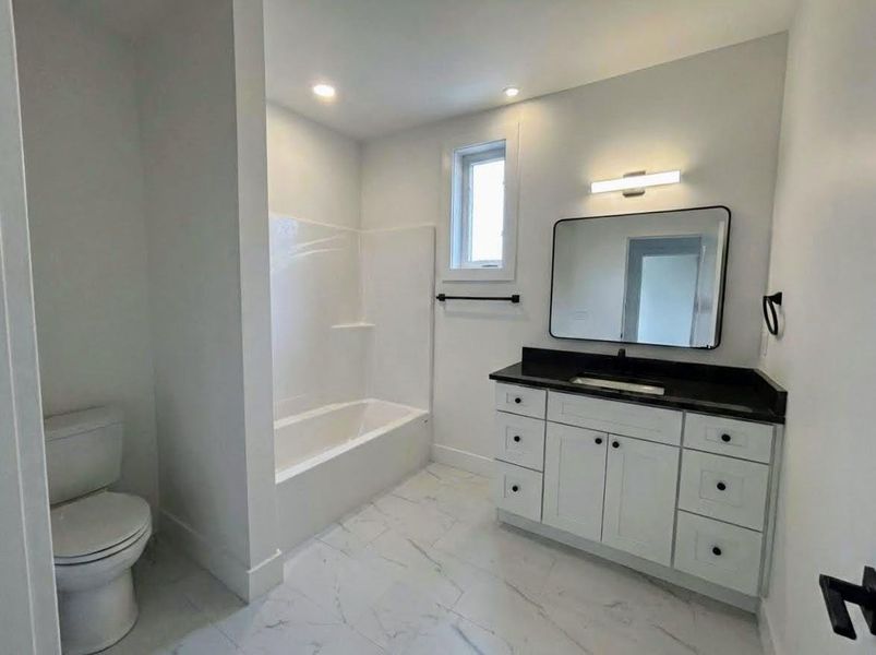 Full bath with vanity, light marble finish floors, shower / washtub combination, and recessed lighting