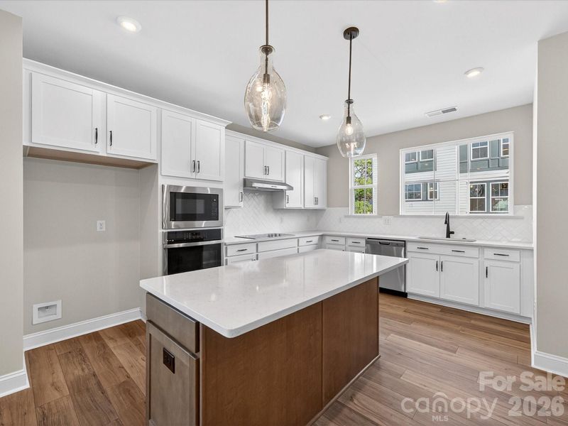Gourmet Kitchen Layout with Designer Pendant Lighting.