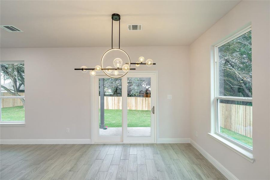 Dining area with light hardwood / wood-style flooring and a chandelier