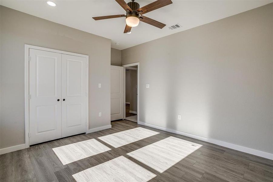 Unfurnished bedroom with a closet, light hardwood / wood-style flooring, and ceiling fan