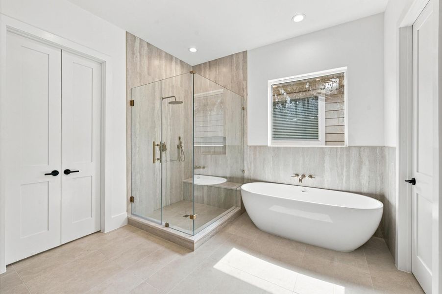 Primary bathroom includes large shower, soaking tub and vanity with dual sinks.