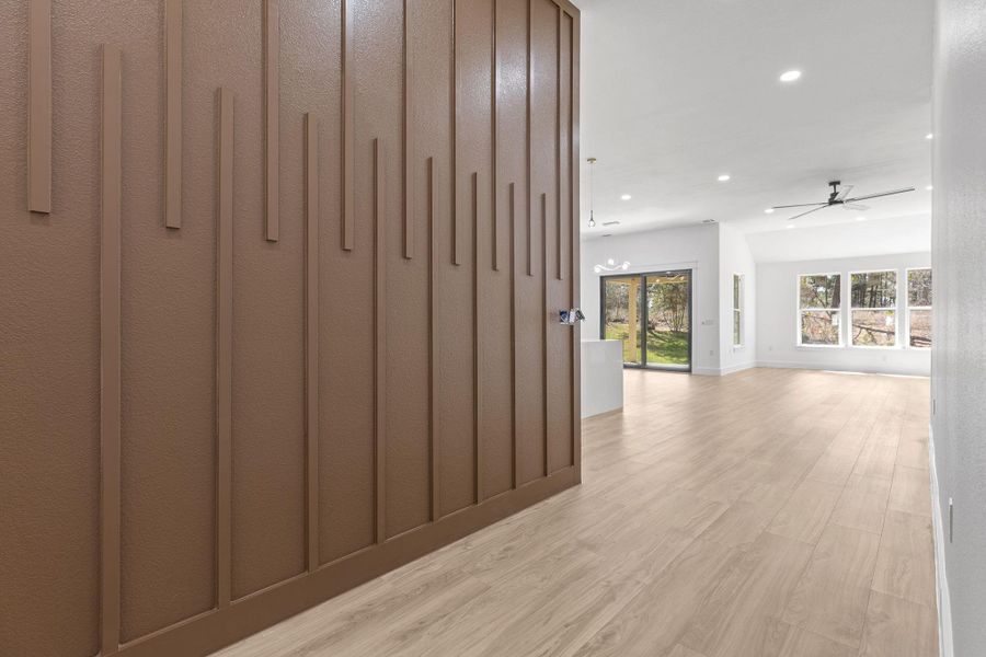 Hall with light wood-style floors and recessed lighting