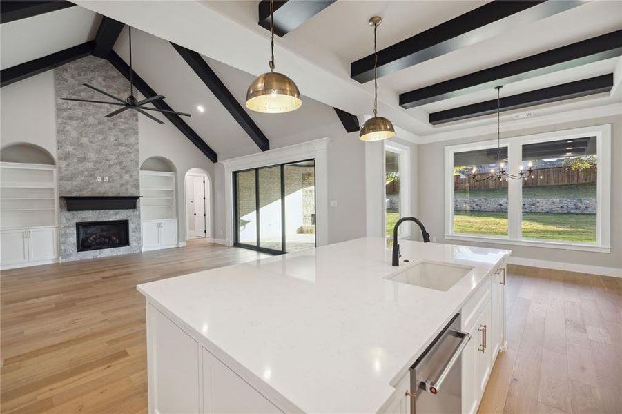 Kitchen featuring pendant lighting, sink, a kitchen island with sink, and light hardwood / wood-style flooring