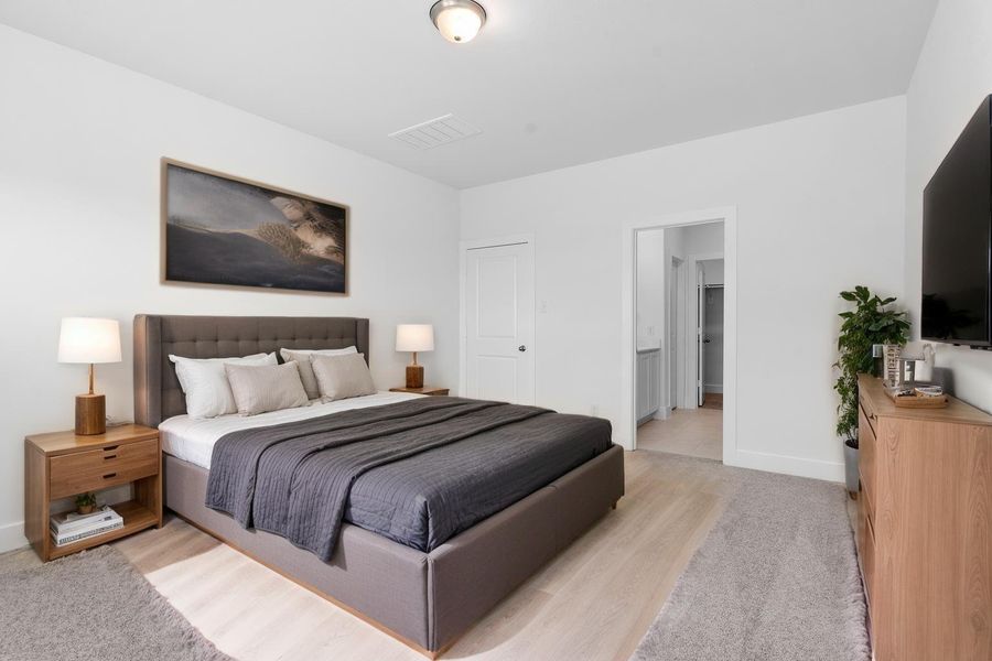 Another view of the spacious virtually staged primary suite! Plush carpet underfoot and a peaceful ambiance make this room a dreamy escape. Its location on the first floor offers extra privacy and convenience. Another view of the spacious virtually staged primary suite! Plush carpet underfoot and a peaceful ambiance make this room a dreamy escape. Its location on the first floor offers extra privacy and convenience.