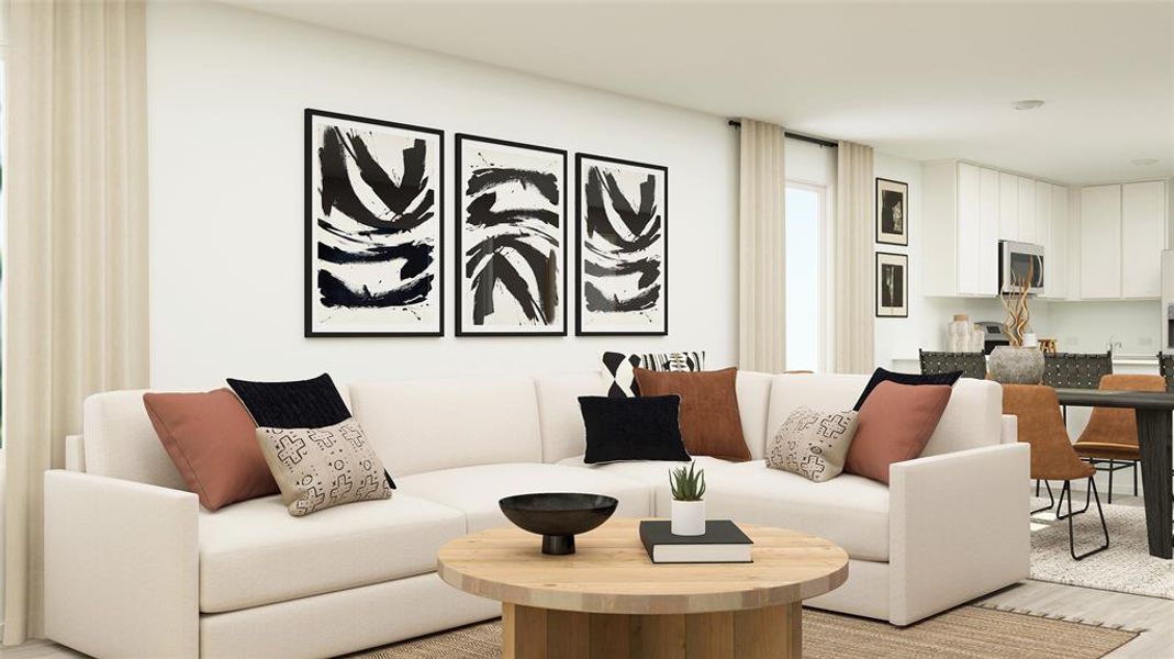 Open-concept living area featuring a light-toned wood-finish coffee table, light wood-finish flooring, and white walls Open-concept living area featuring a light-toned wood-finish coffee table, light wood-finish flooring, and white walls