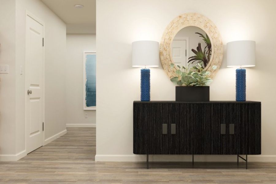 A room with a mirror and a vase with flowers on it. A room with a mirror and a vase with flowers on it.