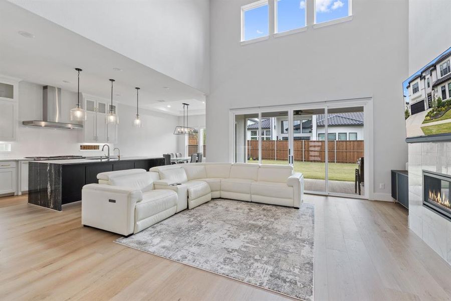 Living room with light wood-style floors and a tiled fireplace