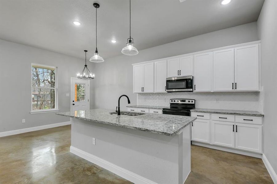 Kitchen featuring finished concrete flooring, electric stove, stainless steel microwave, light stone countertops, and recessed lighting