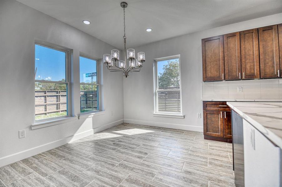 Unfurnished dining area with a wealth of natural light and an inviting chandelier