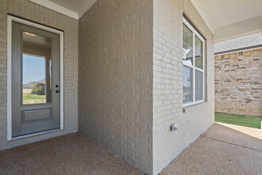 Property entrance with a patio area and brick siding