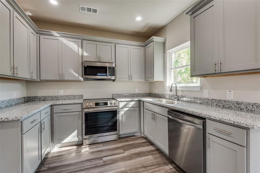 Kitchen with dishwasher, range stove, and microwave