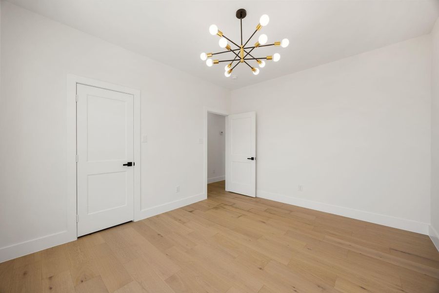 Third level bedroom with  spacious closet and a stylish designer light fixture.