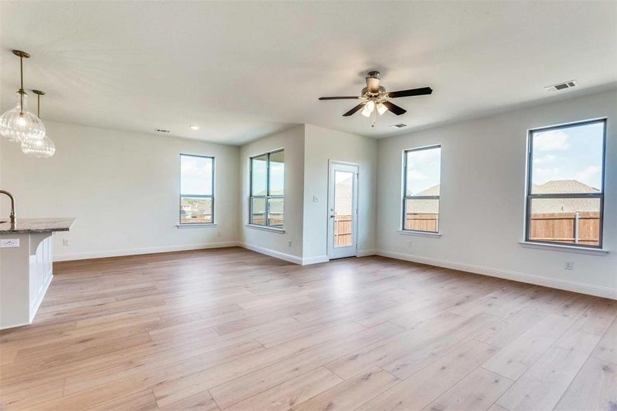 Unfurnished living room featuring plenty of natural light, baseboards, ceiling fan, and recessed lighting