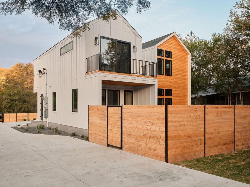 View of front facade featuring board and batten siding and a balcony View of front facade featuring board and batten siding and a balcony