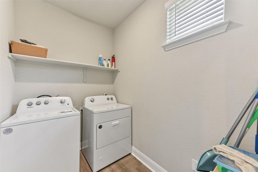 Laundry area featuring separate washer and dryer and wood finished floors Laundry area featuring separate washer and dryer and wood finished floors