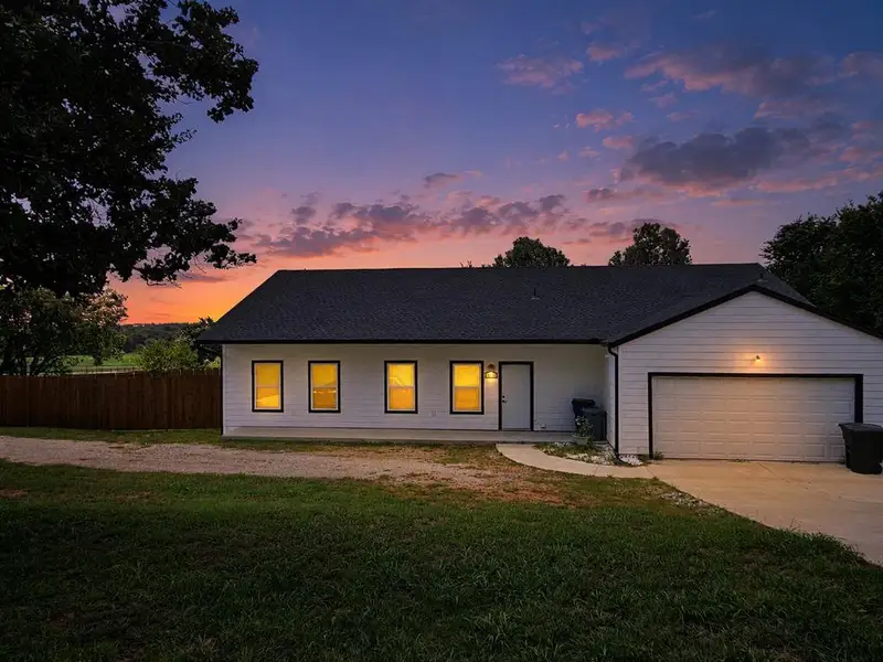 White siding exterior with a dark shingle roof and an attached garage