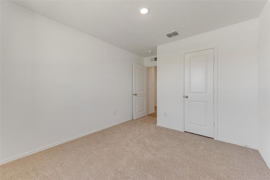 Unfurnished bedroom with light carpet