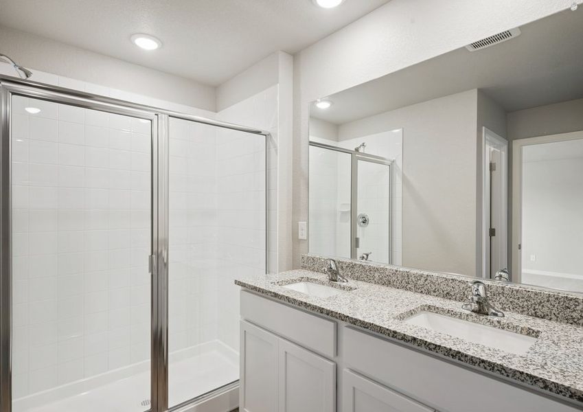 The master bathroom has a dual sink vanity and a step in shower.
