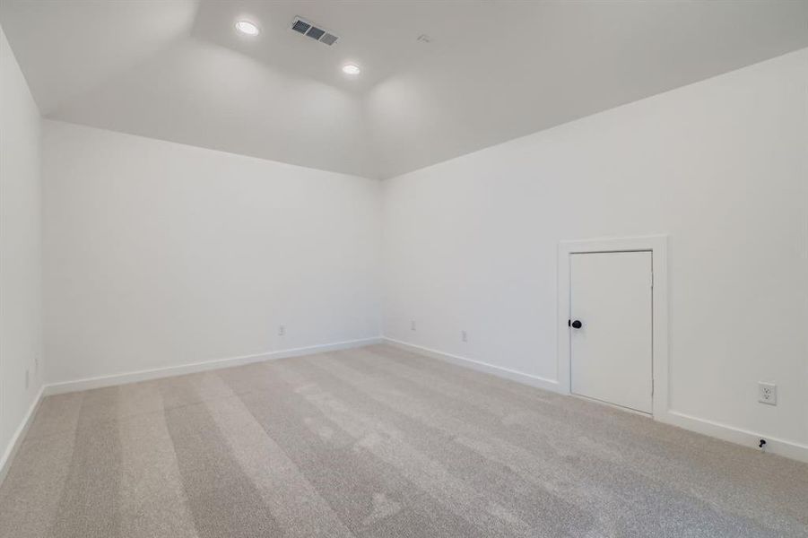 Empty room featuring light colored carpet, recessed lighting, and vaulted ceiling