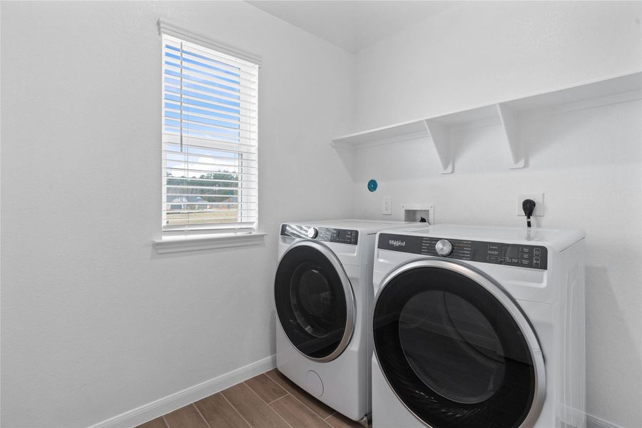 This dedicated laundry room comes equipped with a washer and dryer set, ready for immediate use.